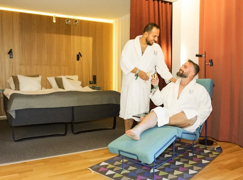Daniele e Luigi di Gayly Planet in accappatoio in una camera di hotel gay-friendly a Stoccolma, ideale per un weekend LGBTQ+ in Svezia