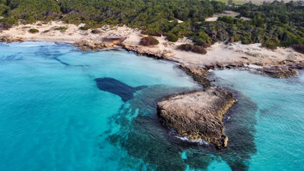 Veduta aerea della spiaggia di Punta della Suina a Gallipoli, nel Salento. Acque cristalline, scogli affioranti e sabbia dorata immersi nella natura incontaminata, una delle spiagge pi&ugrave; belle del Salento