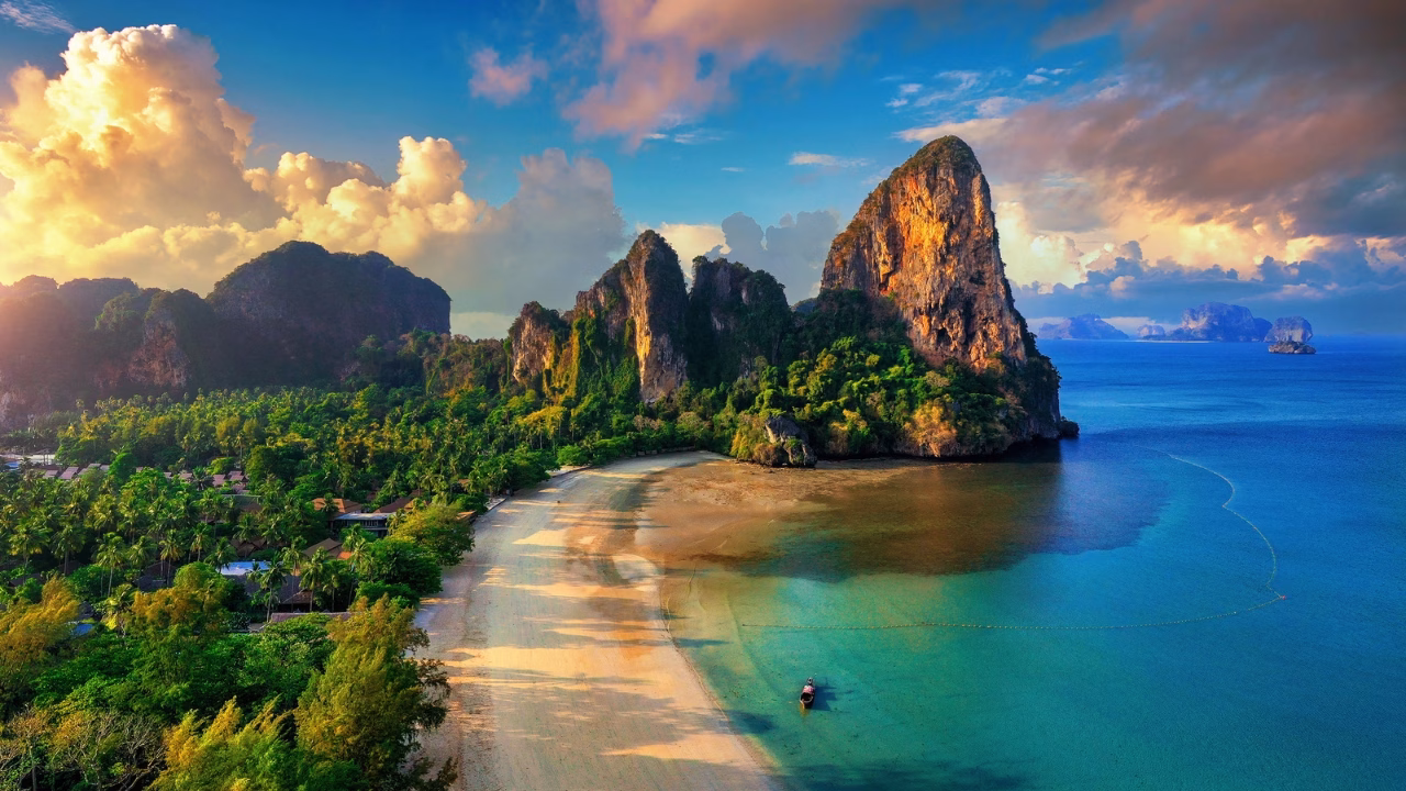 Spiaggia di Railay Beach a Krabi in Thailandia con sabbia dorata mare turchese e imponenti scogliere calcaree illuminate dalla luce del tramonto vista panoramica mozzafiato