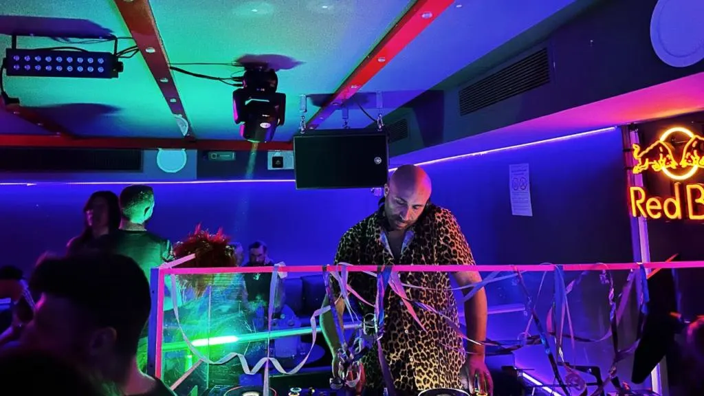 Un dj mentre mette dischi all'Omega Club, la discoteca gay pi&ugrave; famosa di Nizza, tra luci al neon e strobo