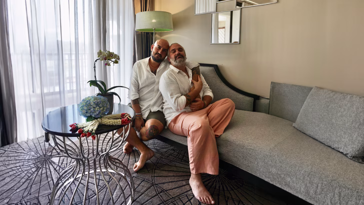 Daniele e Luigi di Gayly Planet abbracciati in una suite di hotel LGBTQ+ friendly, simbolo di relax, romanticismo e accoglienza queer durante un viaggio