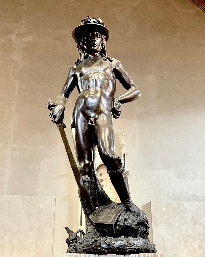 Statua in bronzo del David di Donatello esposta al Museo Nazionale del Bargello di Firenze, raffigurante il giovane eroe biblico con la spada e la testa di Golia ai suoi piedi.