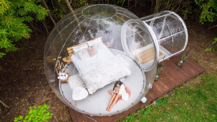 Bubble hotel immerso nella natura, con camera trasparente per dormire sotto le stelle. Letto matrimoniale con arredi eleganti in un&rsquo;esperienza di glamping di lusso. Perfetto per una fuga romantica o un soggiorno insolito nella natura. Hotel sotto le stelle, glamping in Italia, esperienze uniche di viaggio.