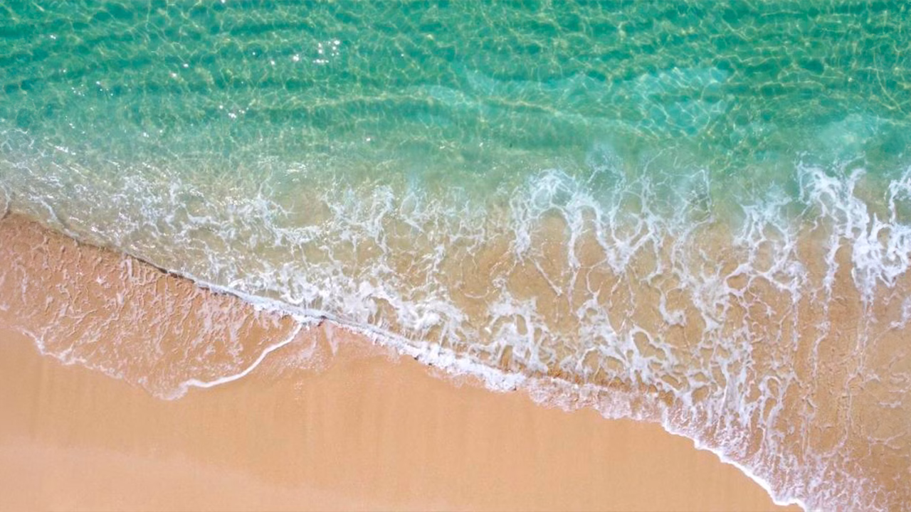 Vista dall&rsquo;alto della spiaggia di Ayala a Campomarino di Maruggio, una distesa di sabbia dorata bagnata da acque cristalline e trasparenti, destinazione amata dalla comunit&agrave; LGBTQ+ nel Salento.
