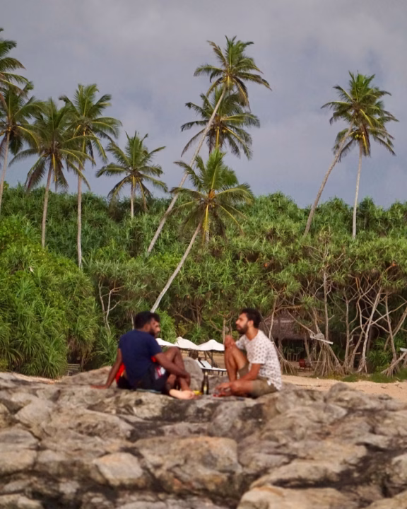 Un gruppo di ragazzi che chiacchiera al tramonto nella spiaggia di Rekawa