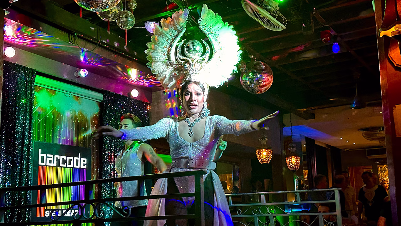 Spettacolo drag al Barcode di Siem Reap, il bar gay pi&ugrave; famoso della Cambogia, con performer sul palco tra luci colorate e atmosfera festosa.