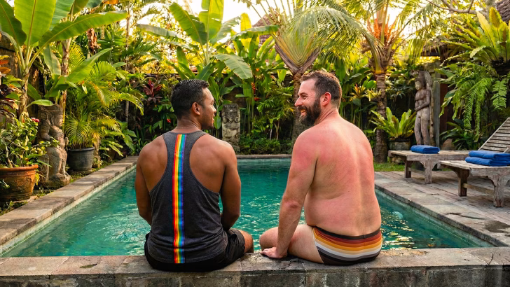 Coppia gay rilassata a bordo piscina in un resort LGBTQ+ friendly di Siem Reap, hotel ideale per viaggiatori gay in Cambogia.