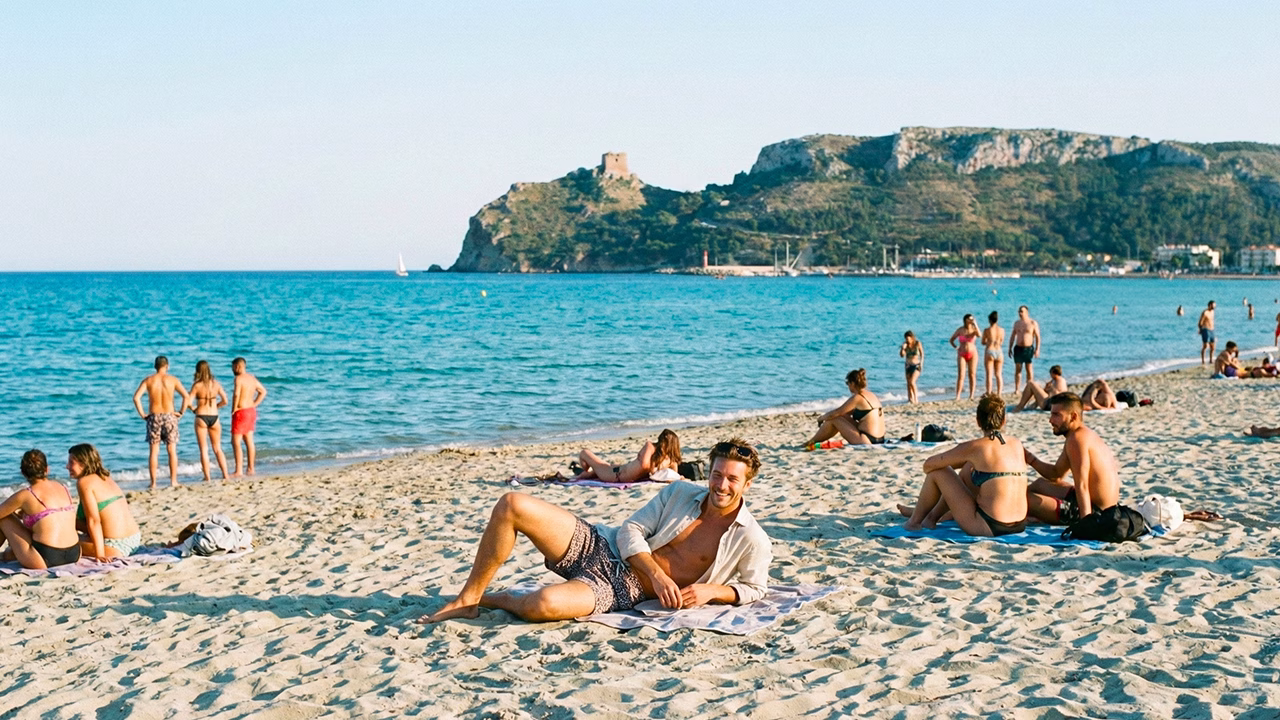 Spiaggia del Poetto a Cagliari con persone che si rilassano al sole, una delle mete pi&ugrave; amate per un viaggio gay-friendly in Sardegna