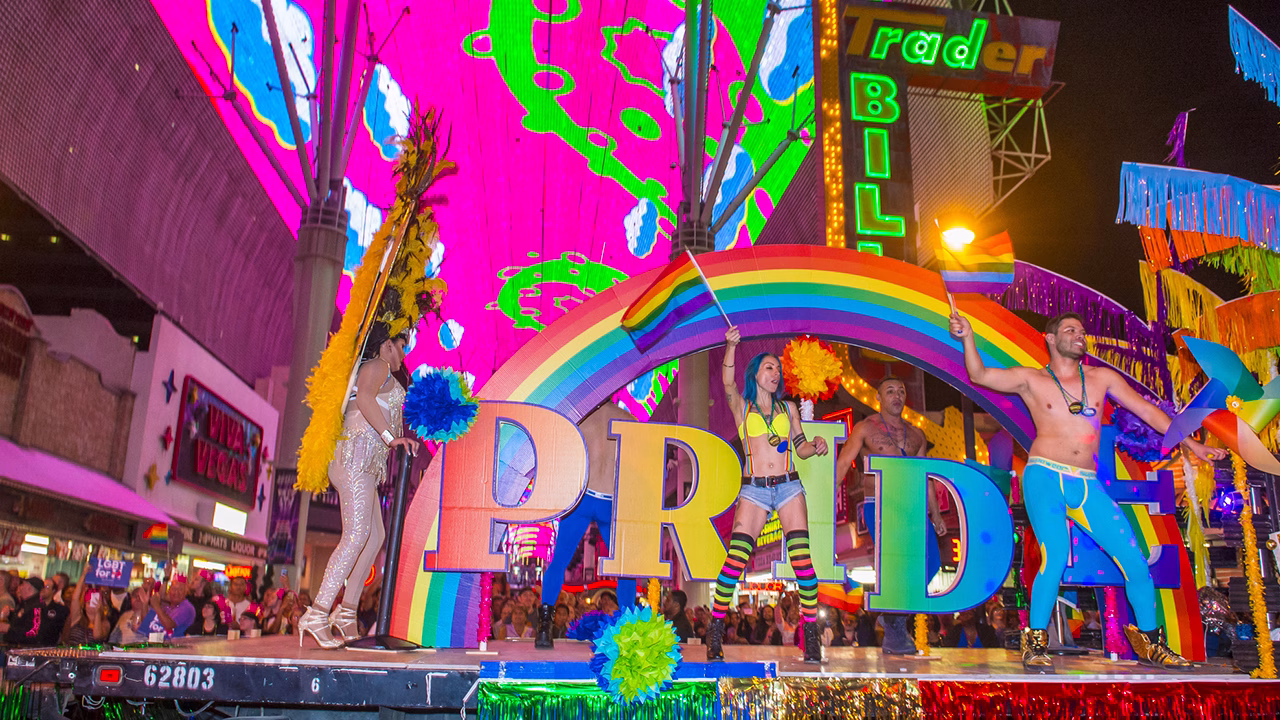 Carro arcobaleno durante il Las Vegas Pride a Fremont Street con bandiere rainbow e folla LGBTQ+ che celebra la parata nel centro di Las Vegas