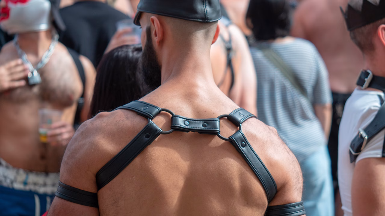 uomo con harness leather durante evento Up Your Alley a San Francisco tra folla fetish